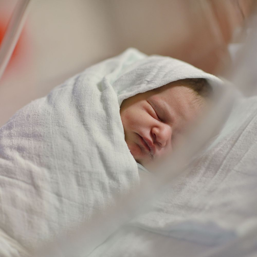Un nouveau né endormi dans un lange blanc